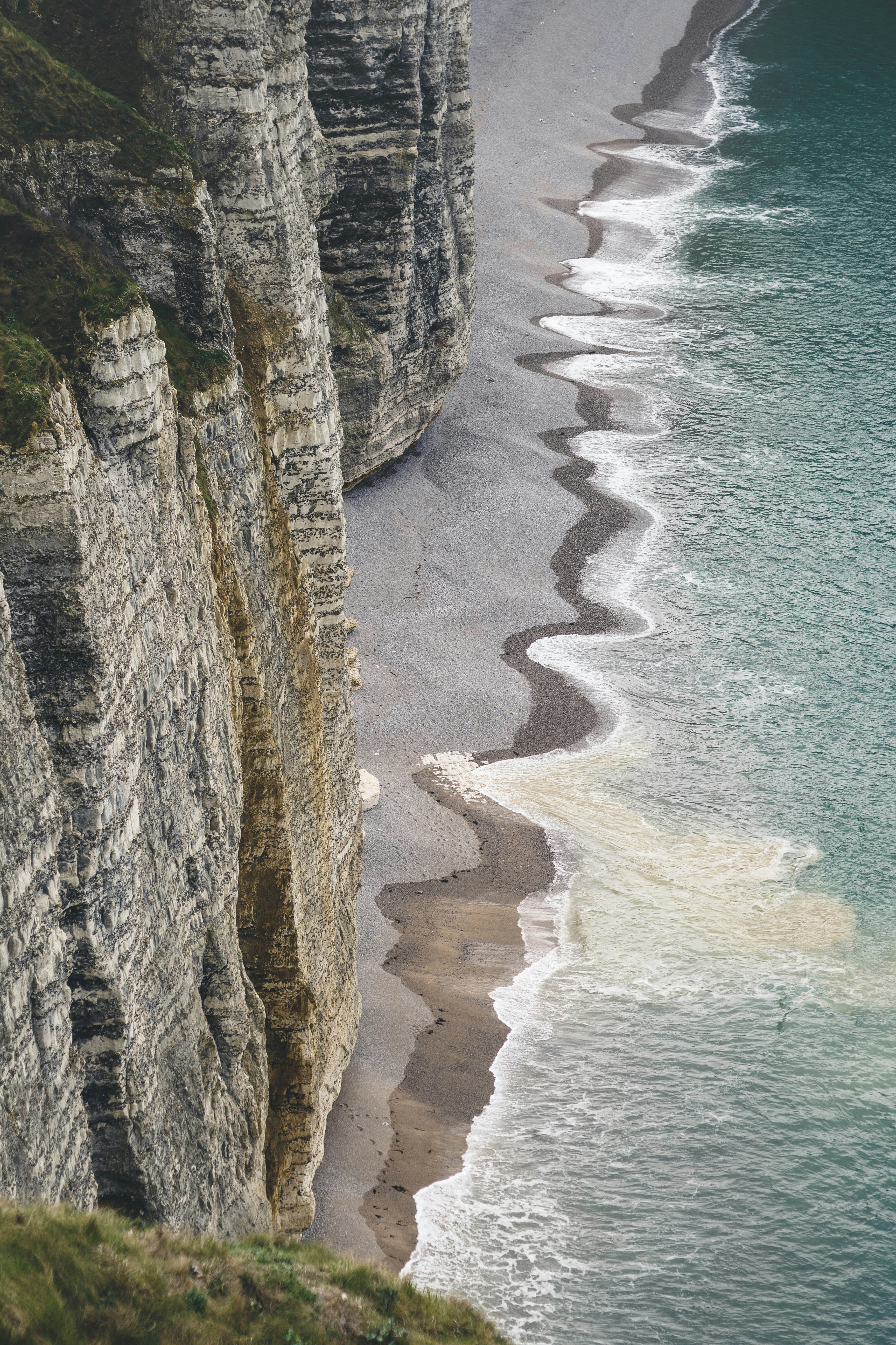 sea waves crushing to shore near rock formation