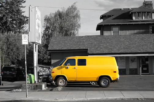 A Velora delivery vehicle parked outside a bright apartment building on a sunny day.