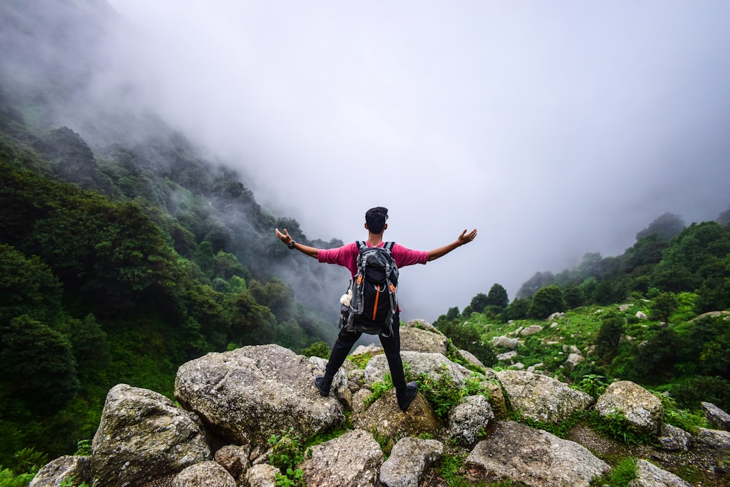 A guy standing on top of a mountain