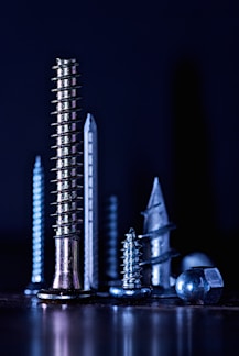 Close-up of various motorcycle bolts and screws neatly arranged on a workshop table.