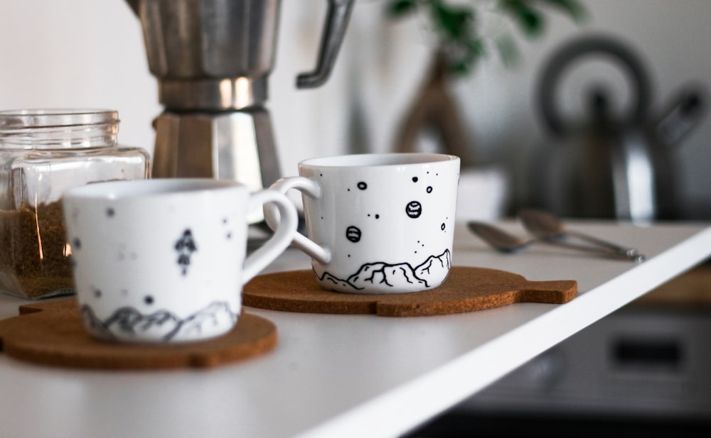 two white cup on brown trays