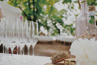 A beautifully arranged champagne table set outdoors with glasses and decorations for a wedding celebration.