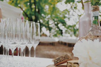 Elegant mobile bar setup with wine bottles and sparkling glasses at an outdoor event.