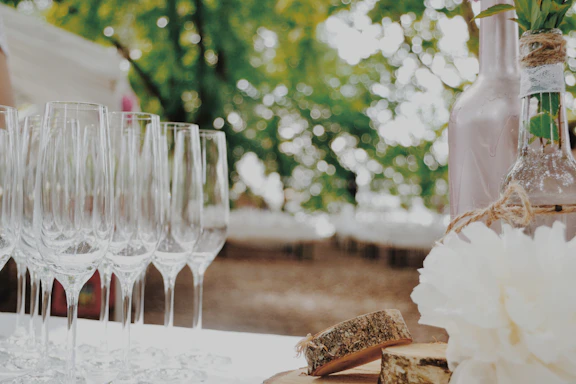 A cozy champagne table setup with glasses and flowers at an outdoor wedding.
