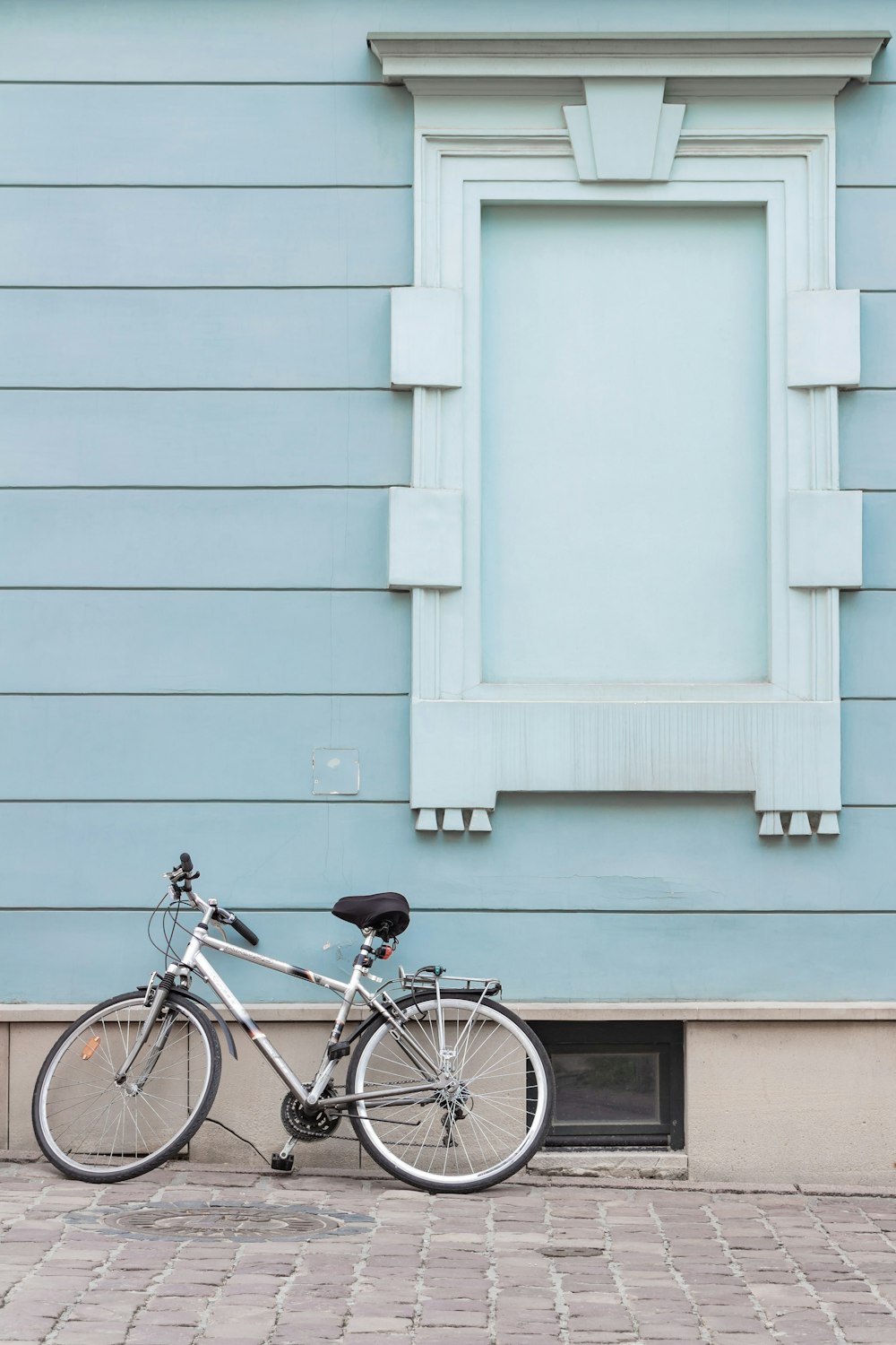 gray city bike parking on pavement on wall