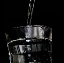 Close-up of sparkling clear purified water pouring into a glass.