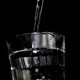 A close-up of fresh water pouring into a clear glass, highlighting freshness.