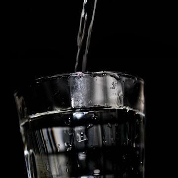 Close-up of crystal-clear water pouring into a glass, highlighting purity.