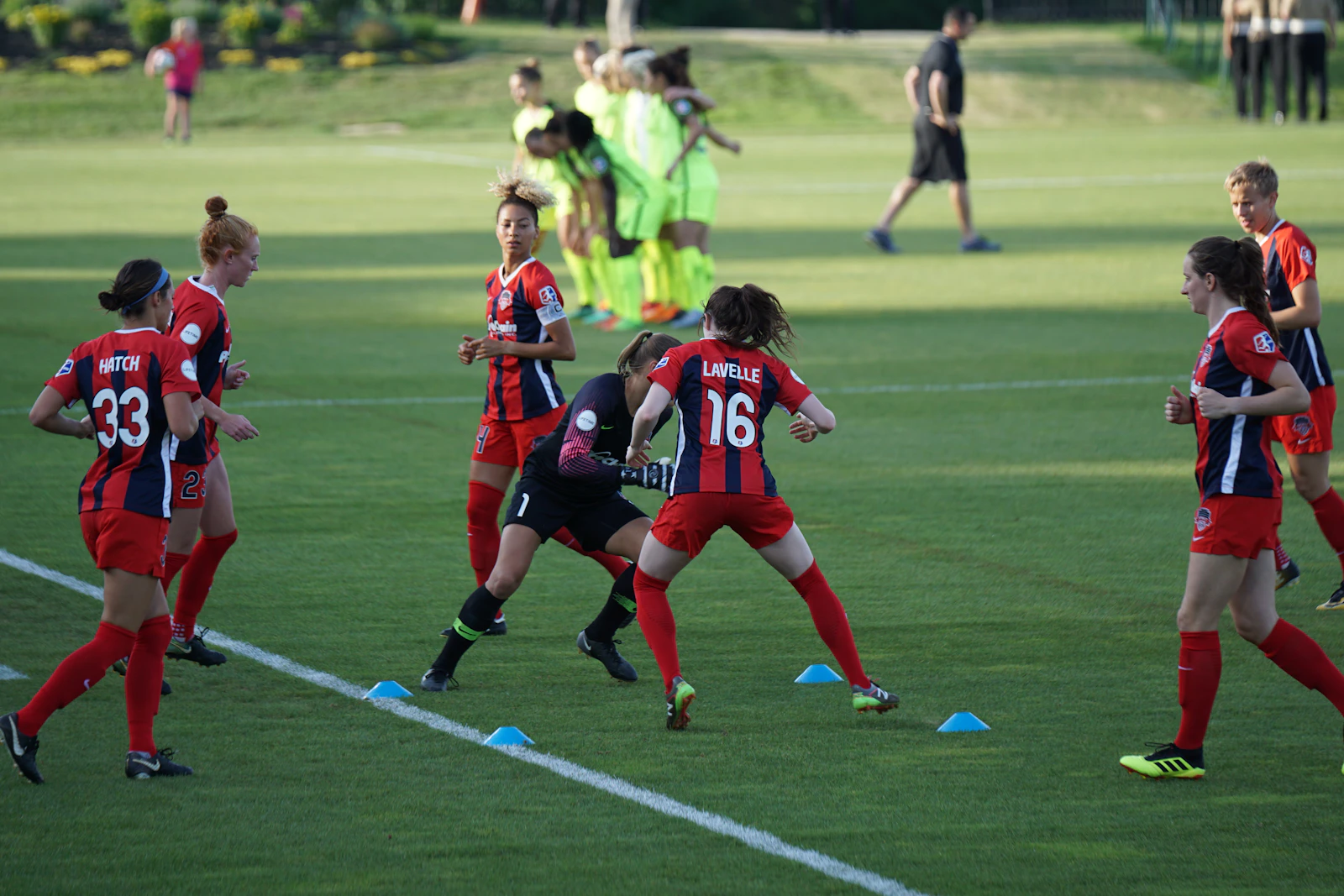 Women's soccer team huddle — multicultural players united on the pitch