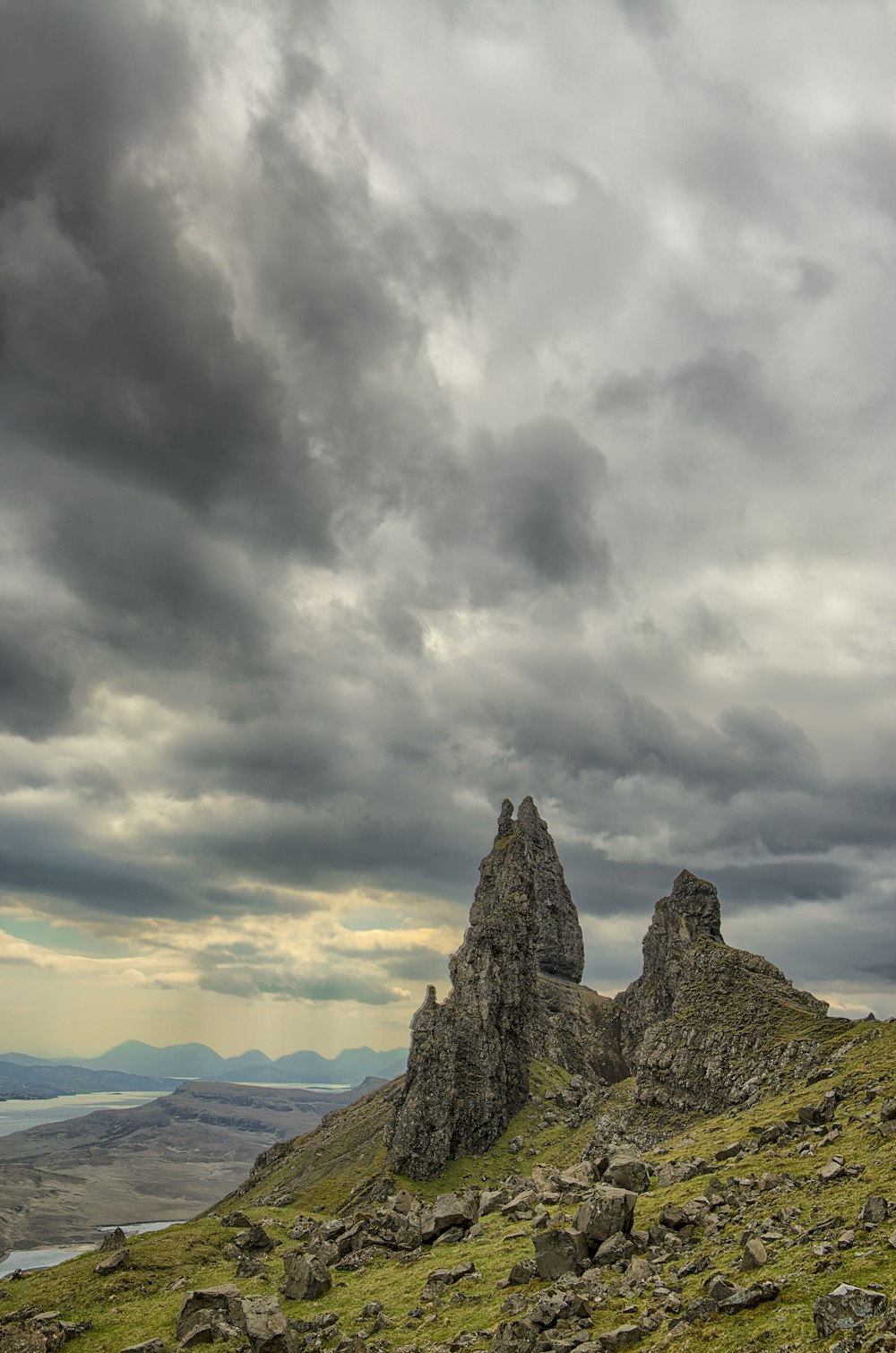 photographie de paysage de colline rocheuse verte et grise sous un ciel nuageux