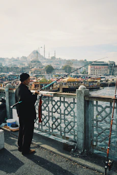 man fishing using black and blue fishing rod