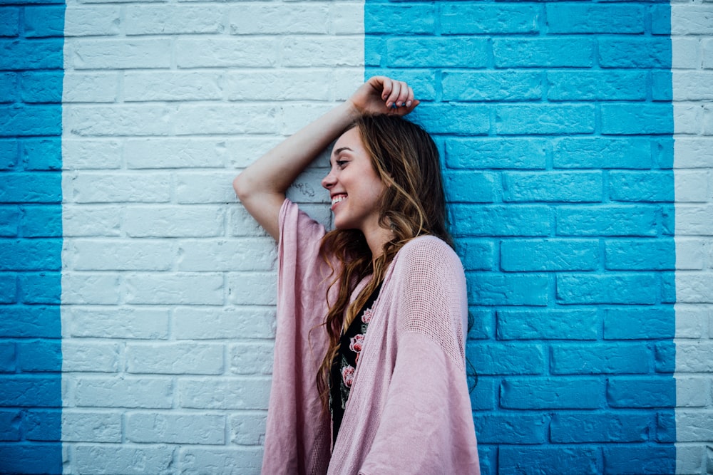 woman leaning on blue and white wall