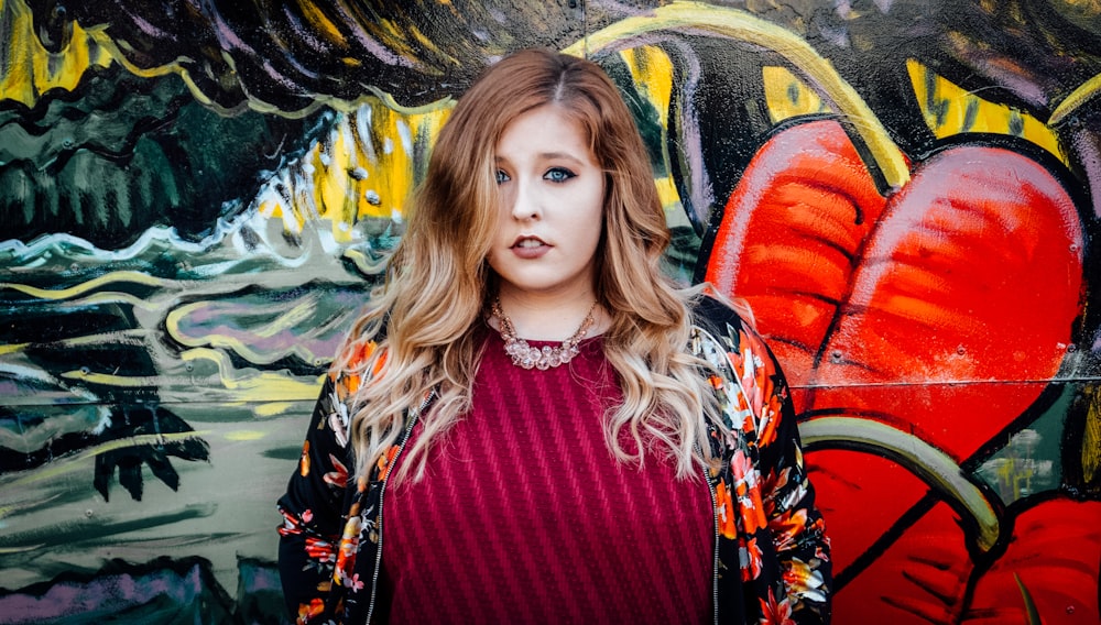 woman standing in front of wall mural