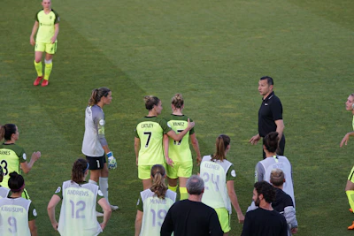 Dynamic shot of a soccer team wearing matching custom kits on a vibrant green field.