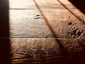 Close-up of a warm-toned hardwood floor with natural grain patterns in a sunlit living room