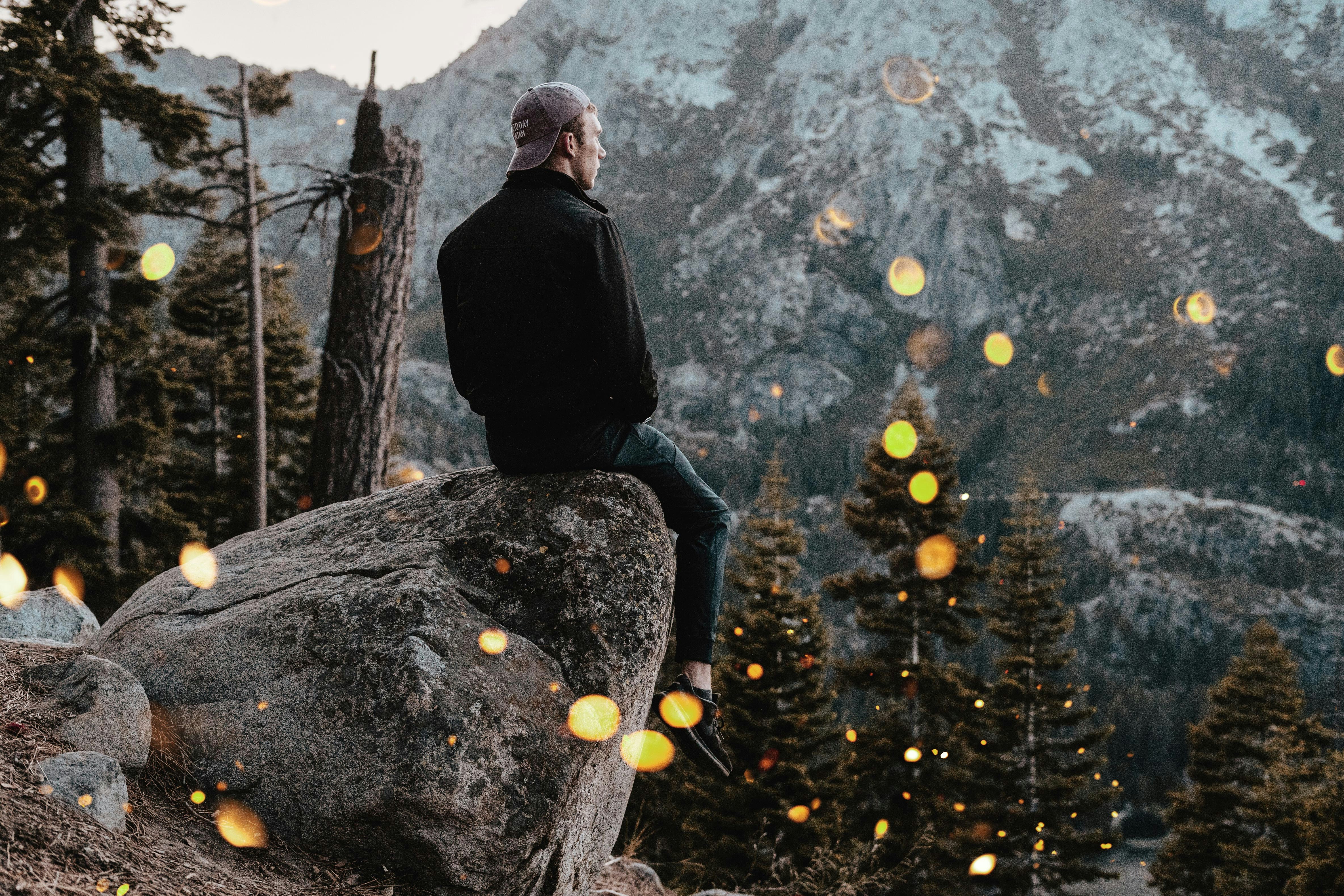 man sitting on rock