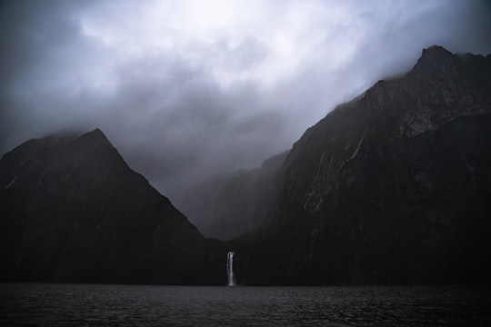 waterfalls in mountain near ocean in Southern Discoveries - Milford Sound New Zealand