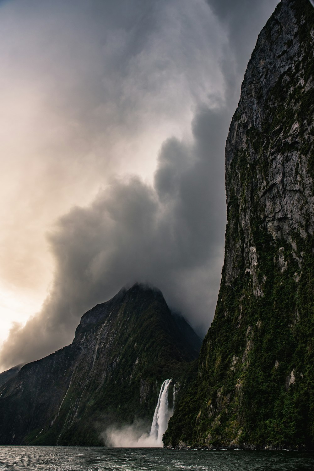 low angle photo of waterfalls between mountains