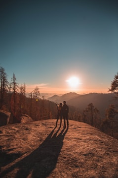 silhouette of man and woman on hill