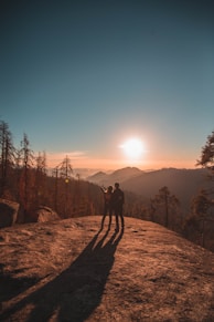 silhouette of man and woman on hill