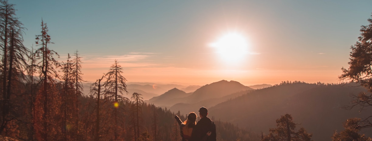 silhouette of man and woman on hill