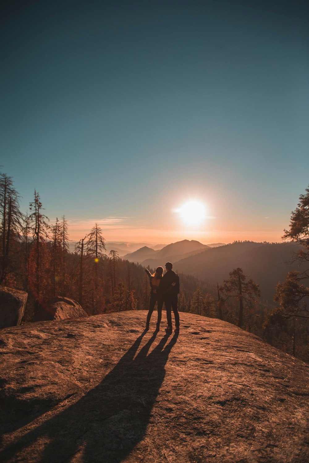 silhouette of man and woman on hill