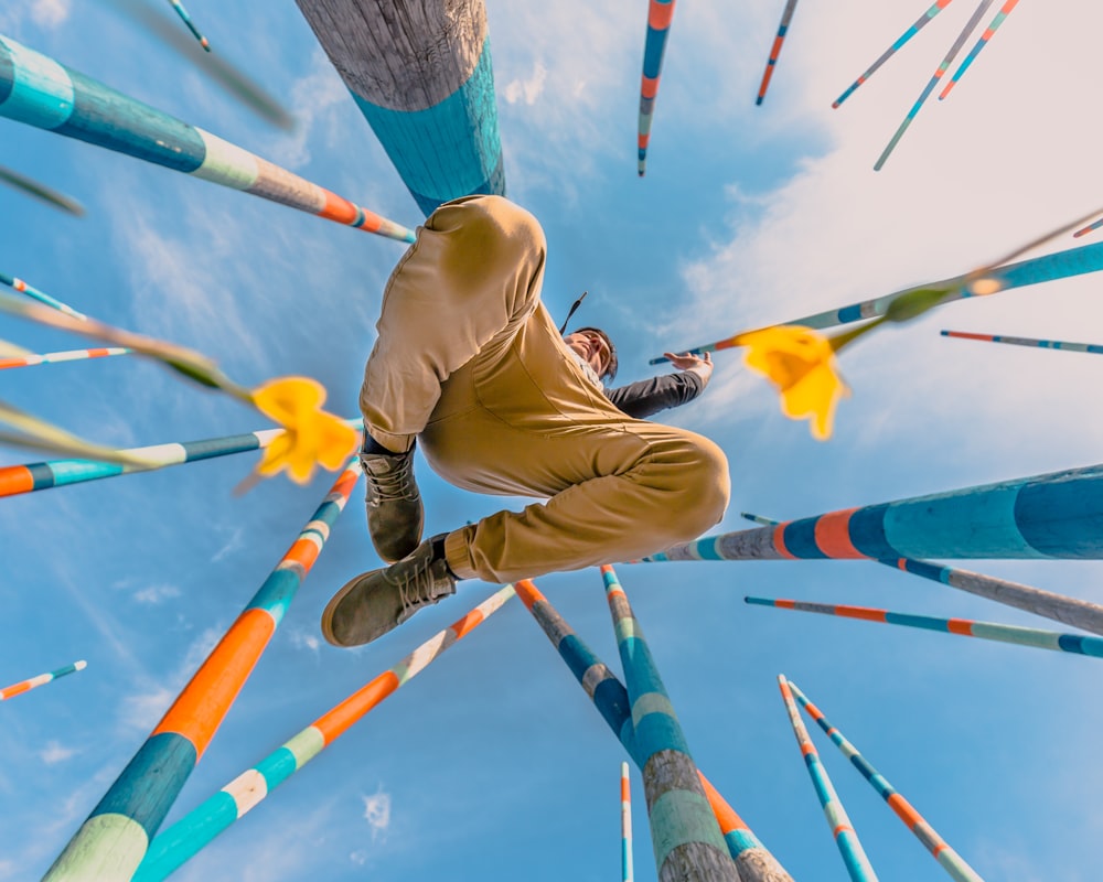 man jumping beside bamboo sticks