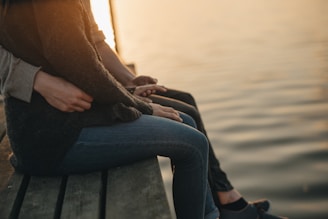 man and woman sitting on dock