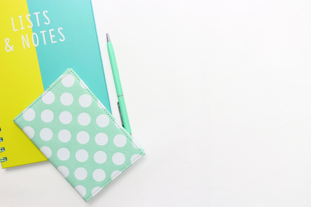 teal and white polka-dot wallet on table