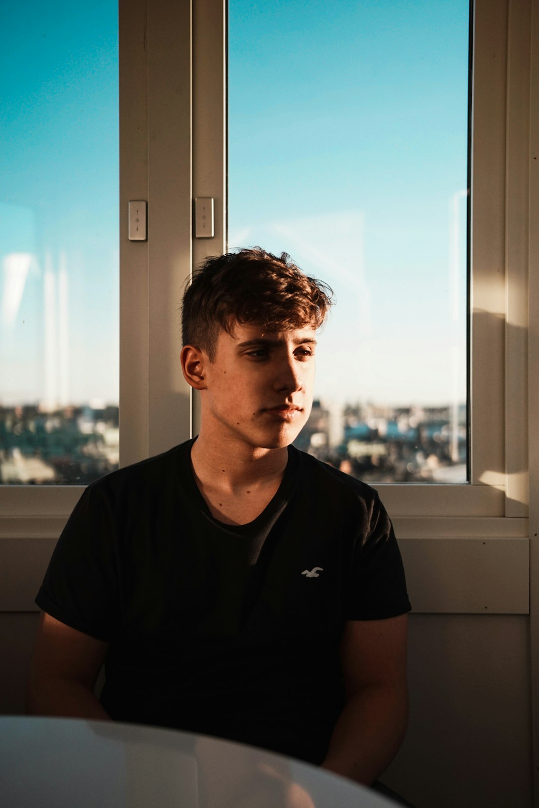 man sitting in front of glass window