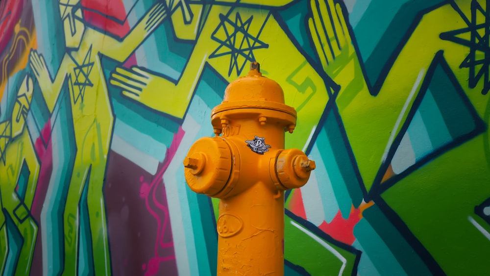 orange fire hydrant near mural wall
