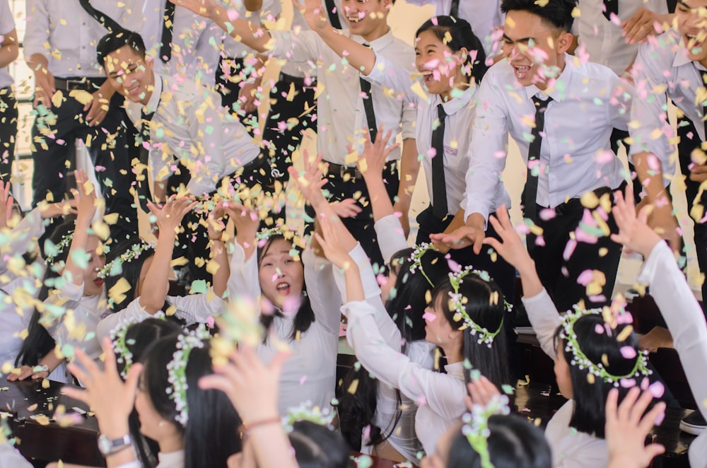 people in white shirts throwing confetti