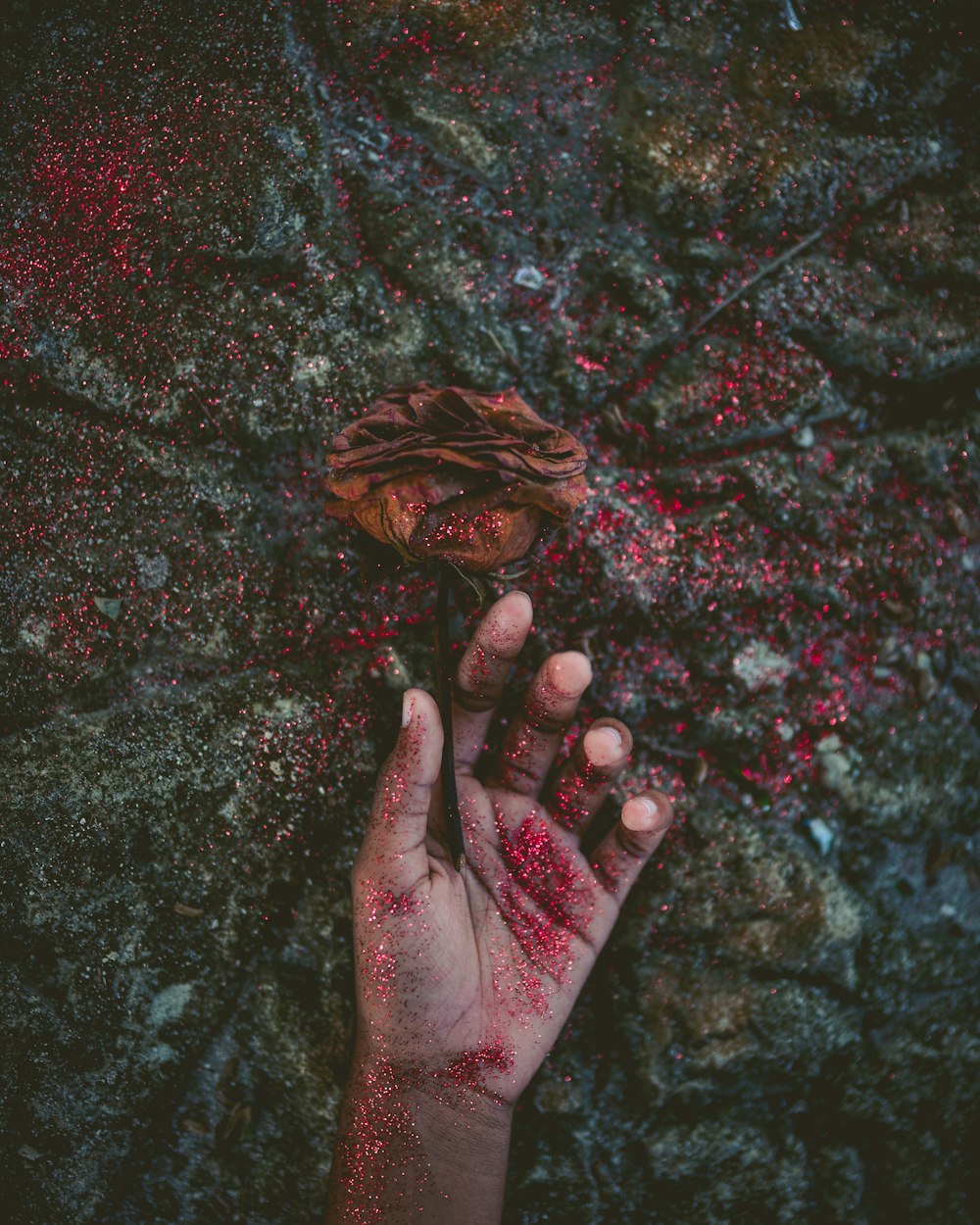 person's left hand covered with red glitters