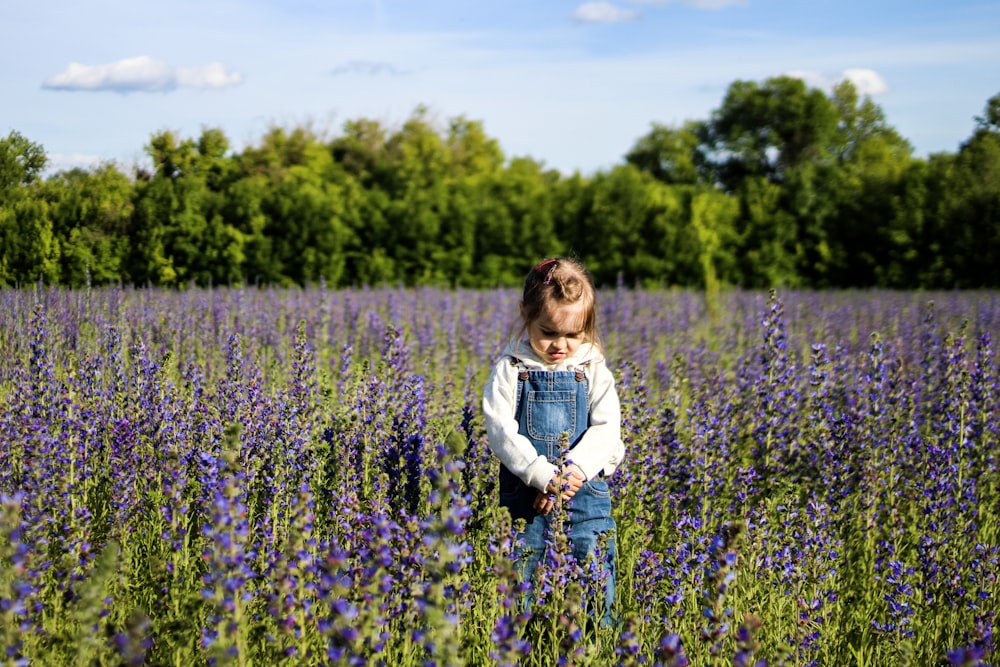 Muchacha de pie en el campo de flores púrpuras