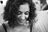 Close-up of a woman with beautifully defined tight curls smiling softly.