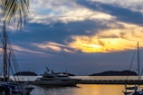 A panoramic view of a luxury yacht anchored offshore, surveyed remotely at sunset.
