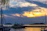 Sunset view from the deck of a luxury expedition yacht cruising near a secluded island.