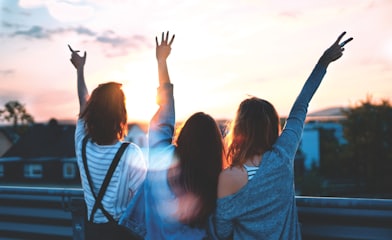 Photo of three women lifting their hands