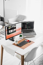 black flat screen computer monitor and laptop on table