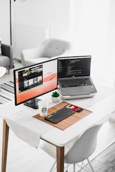 black flat screen computer monitor and laptop on table
