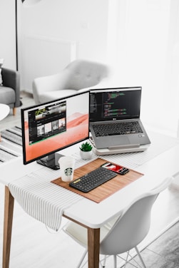 black flat screen computer monitor and laptop on table