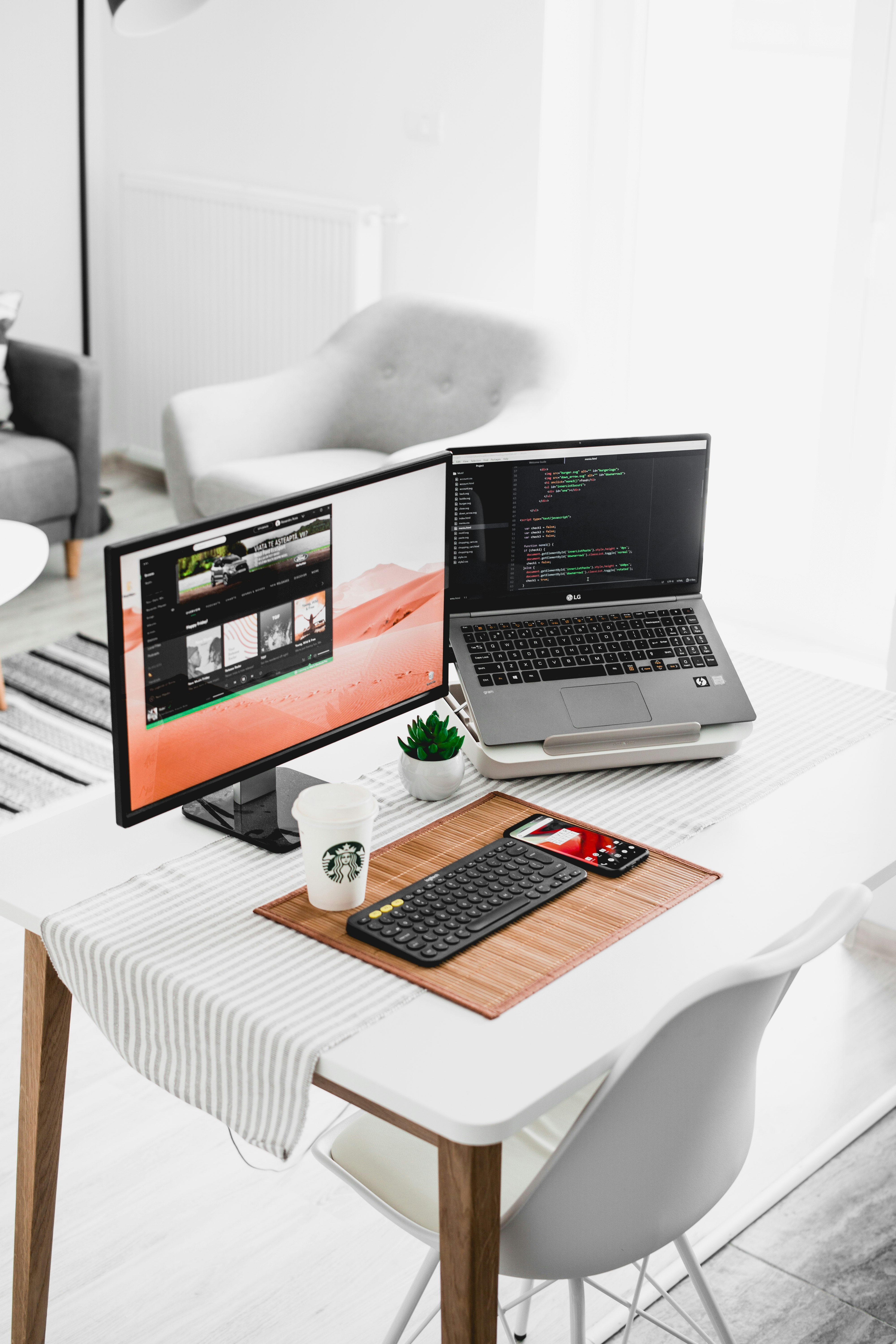 black flat screen computer monitor and laptop on table