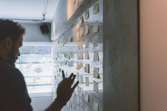 male putting sticky notes on wall