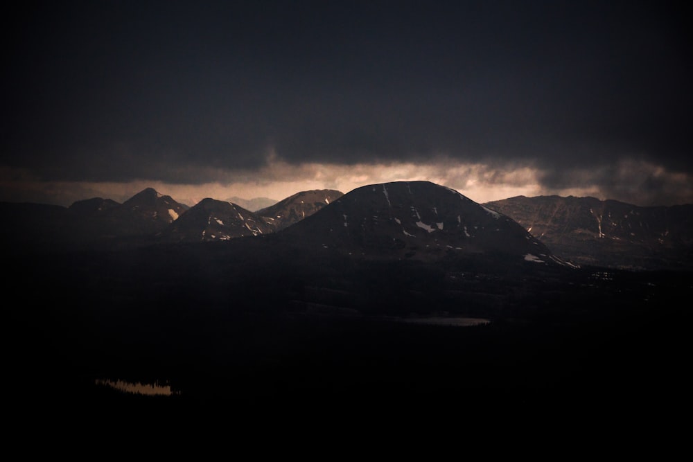 silhouette of mountain under cloudy sky