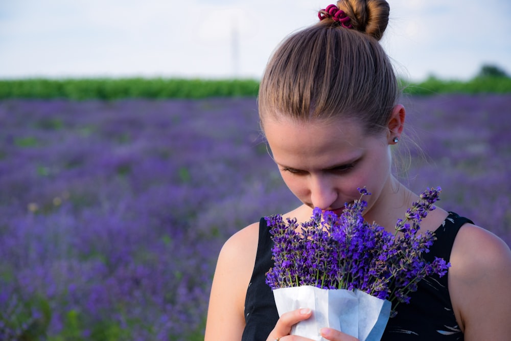 mulher cheirando buquê de lavanda roxa