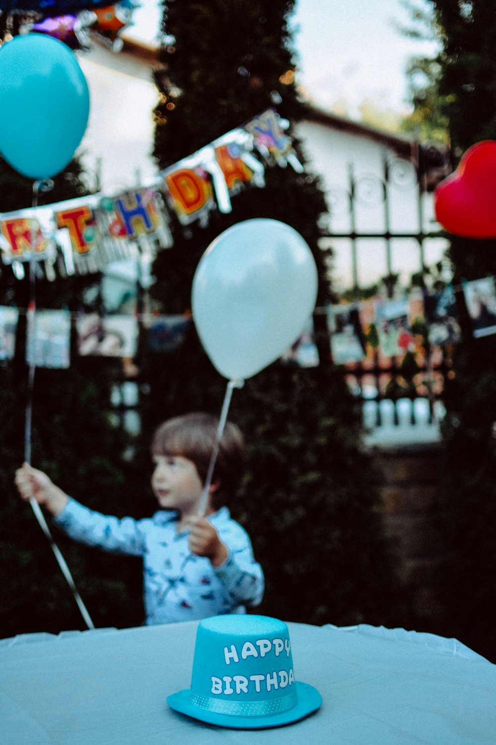 chico sosteniendo globos azules y blancos en la fiesta