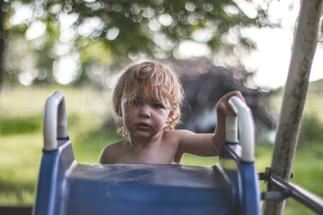 children climbing on slide, A rite of passage as a young boy makes his first climb to the top of the slide on his own. H