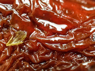 Sun-dried tomatoes laid out on a traditional Sicilian cloth, showcasing rich red hues.