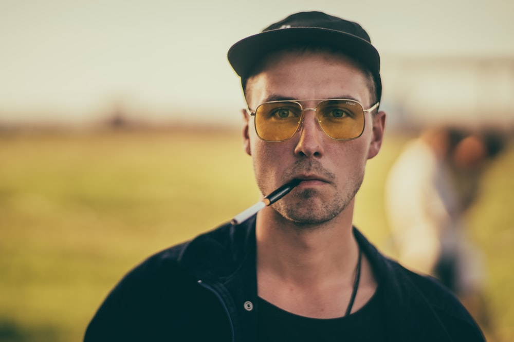 shallow focus photography of man smoking cigarette