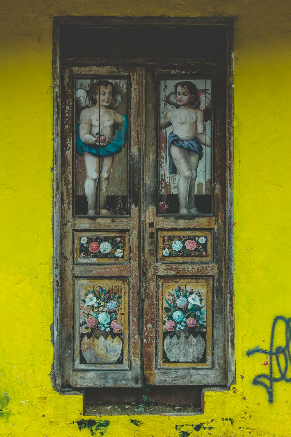 天使と花の絵が描かれた木製のドア